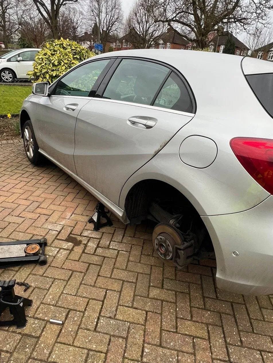 Wheel removed for a brake inspection on a car parked at the customer's home